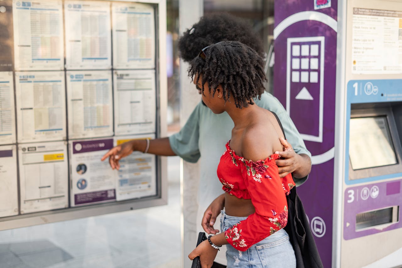 A couple checking the bus schedule at an urban bus stop, planning their journey.